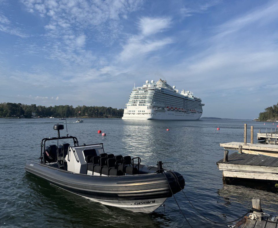 Large RIB charter boat moored in the Stockholm archipelago with a large cruise ship in the background, showcasing private boat tours with 59 DEGREES NORTH.