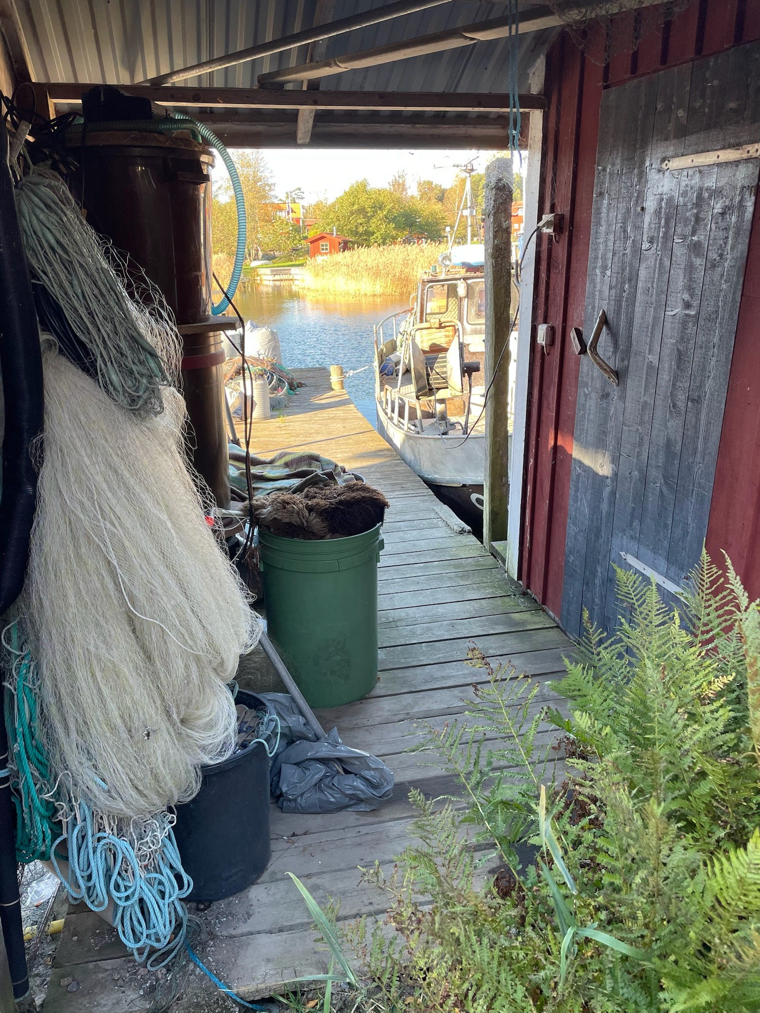 Private RIB Speedboat Tours in the Stockholm Archipelago Traditional old boatshed with fishing nets on the island of Möja in the Stockholm archipelago, photographed during a private RIB charter with 59 DEGREES NORTH.