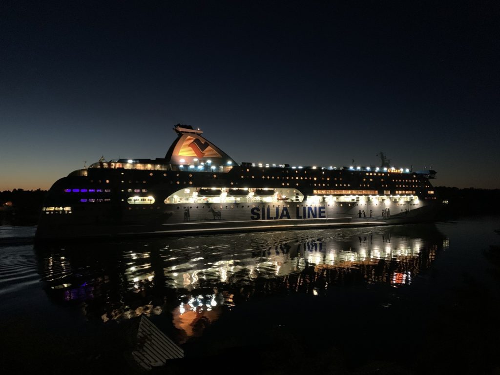 Skärgårdsupplevelser med RIB‑båt i Stockholms skärgård Silja Line cruise ferry illuminated at night in the Stockholm archipelago, showcasing maritime traffic and evening views experienced during RIB speedboat tours with 59 Degrees North
