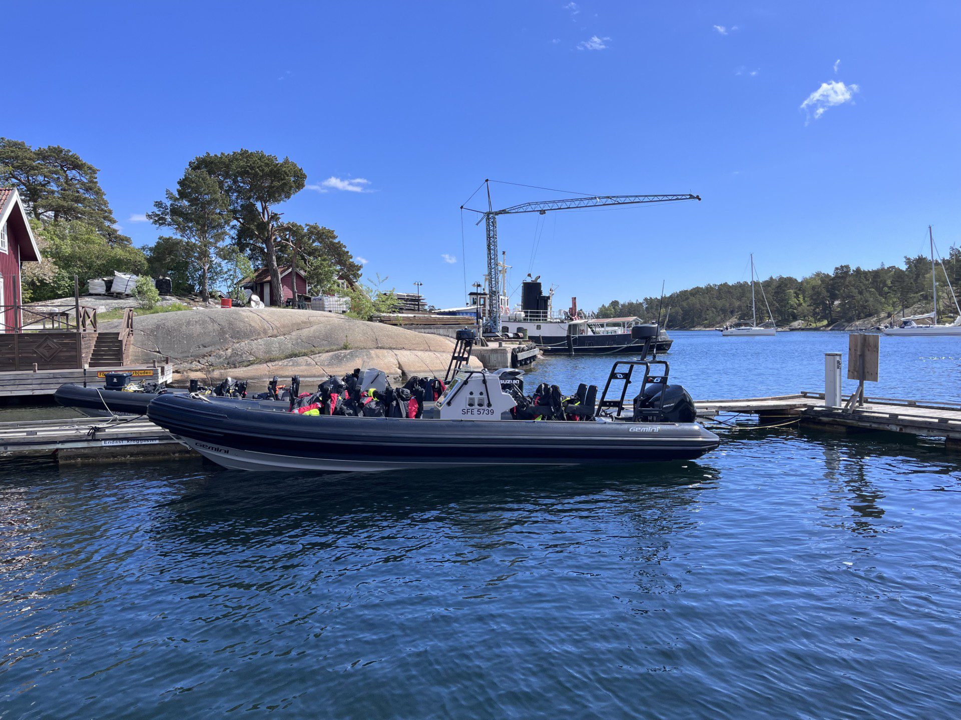 Luxury RIB speedboat docked at Ingmarsö Krog in the Stockholm Archipelago, with guests enjoying a lunch stop by the seaside